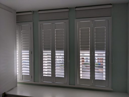 Bedroom shutters layered with roller blinds to block out light for a better night's sleep