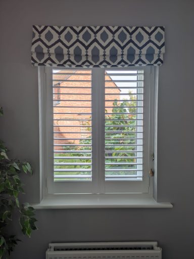 Modern dining room with white shutters and roman blind