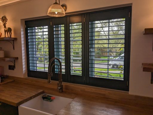 Contemporary kitchen with bottle green window shutters